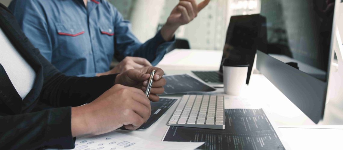 binome de travailleurs qui échangent devant un PC